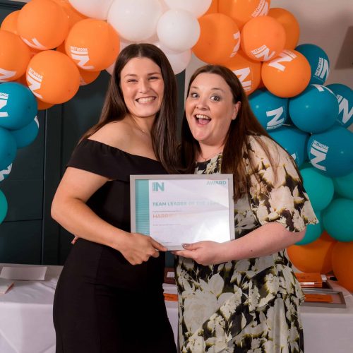 Happy award winners on stage with trophies at the Manor House Hotel in Alsager, professional event photography in South Cheshire.