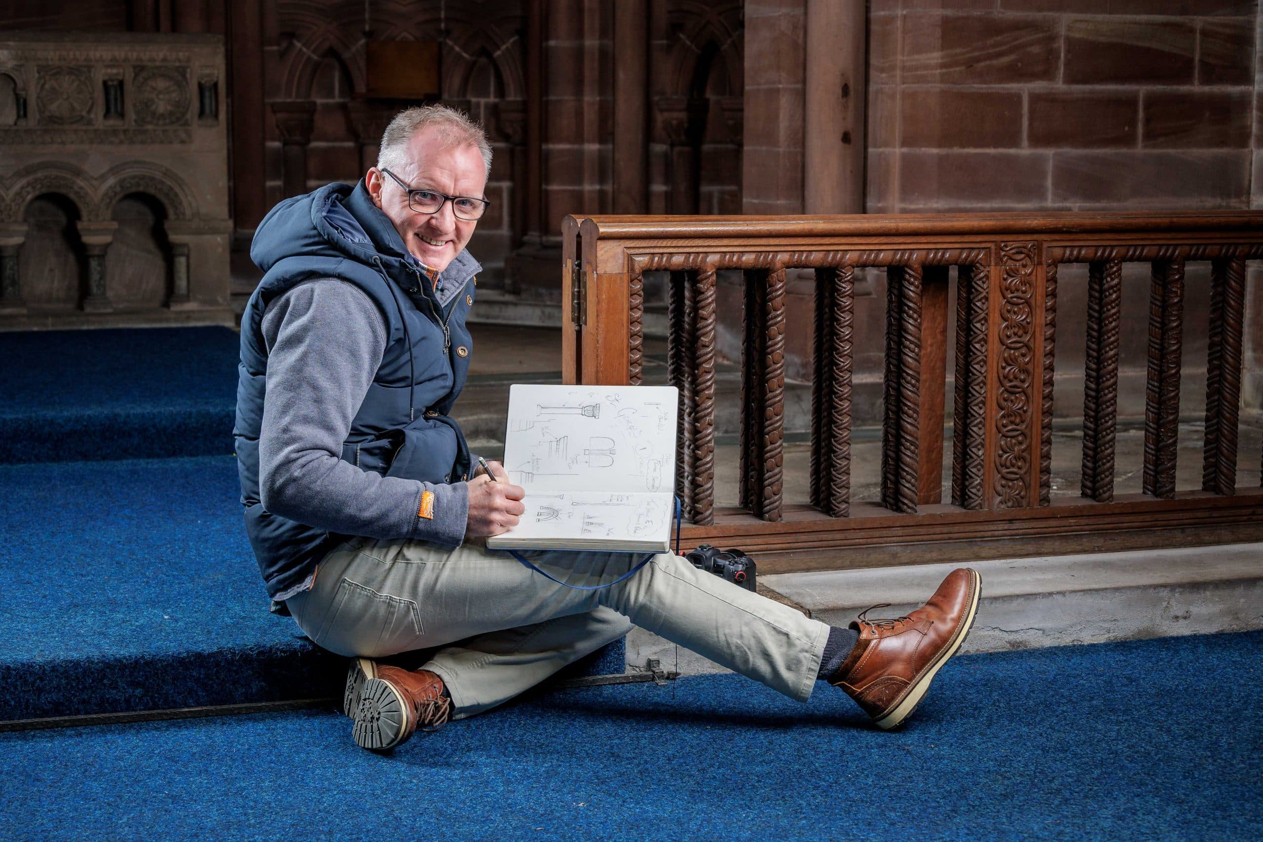 Man sitting in church by altar posing for photographer